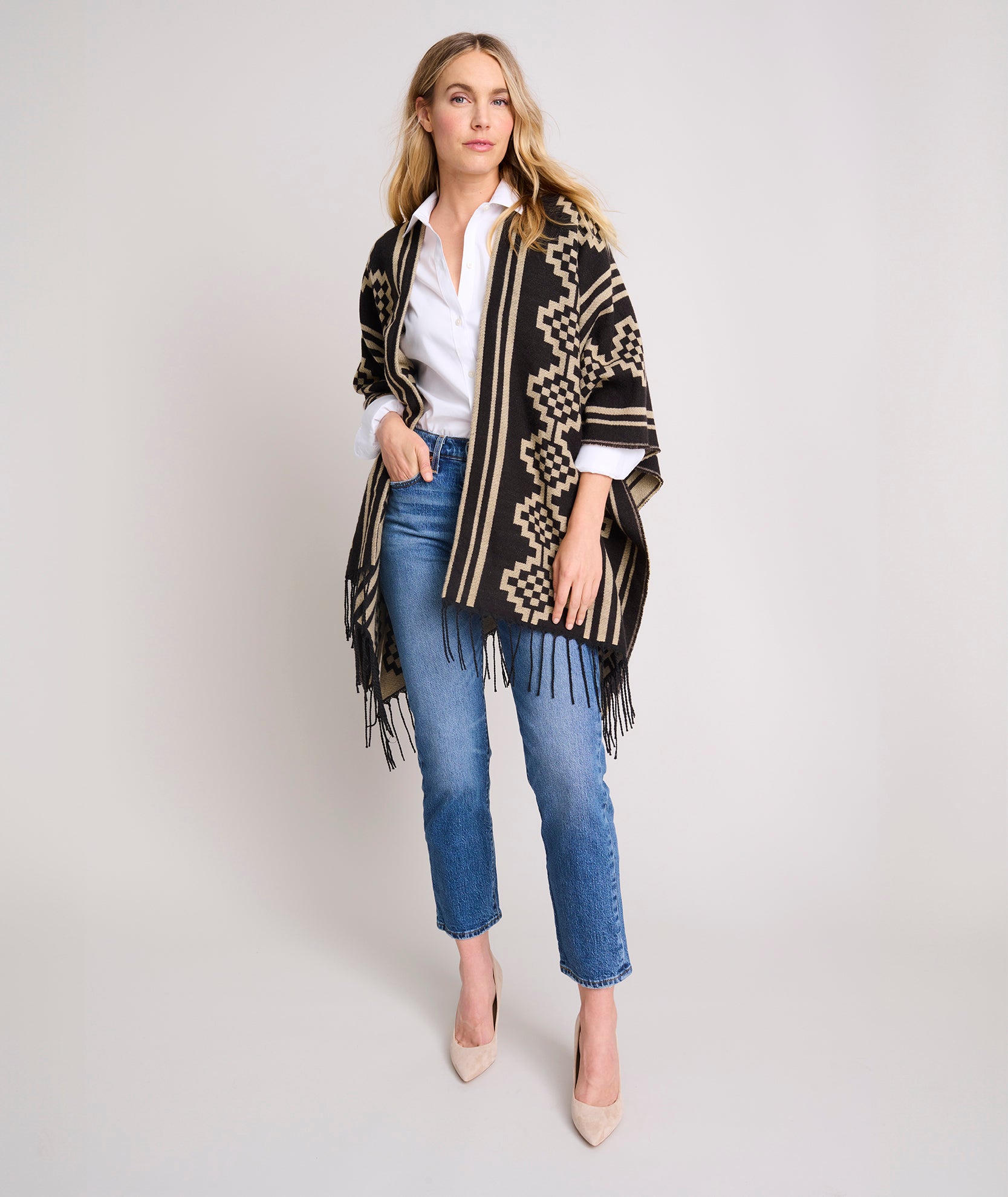 Model is wearing UNTUCKit Fringe Trim Geo Print Poncho.