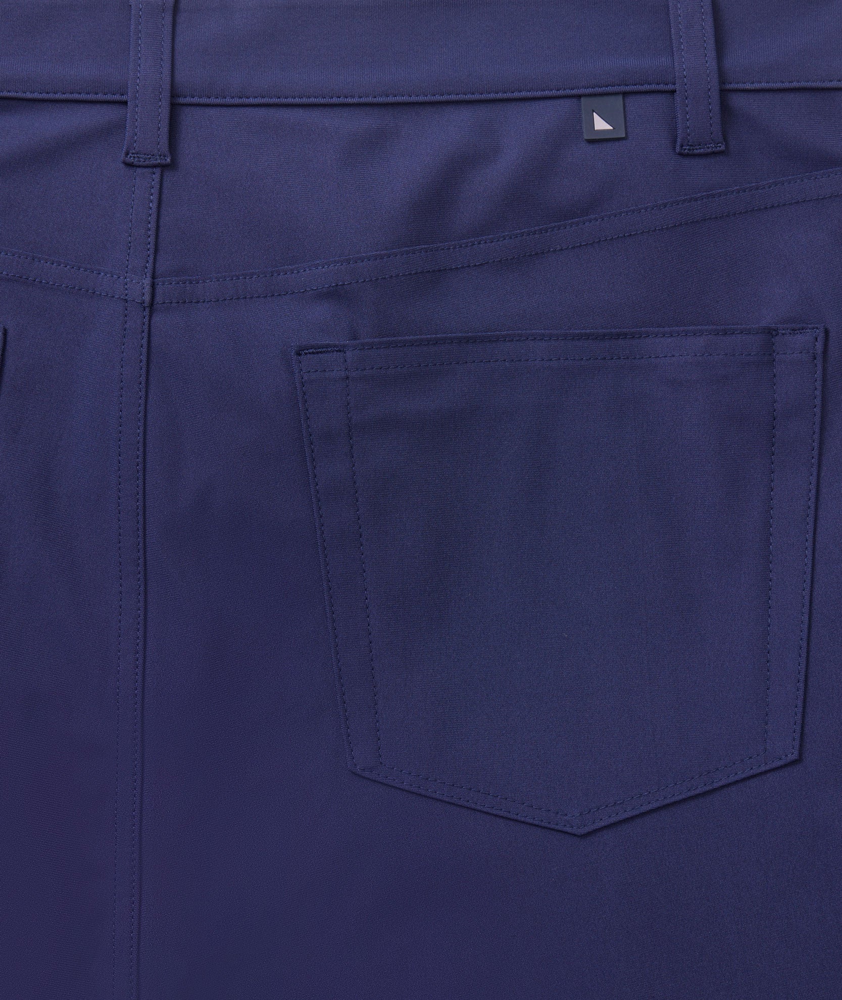 Model is wearing UNTUCKit 5-Pocket Tech Pant in navy.