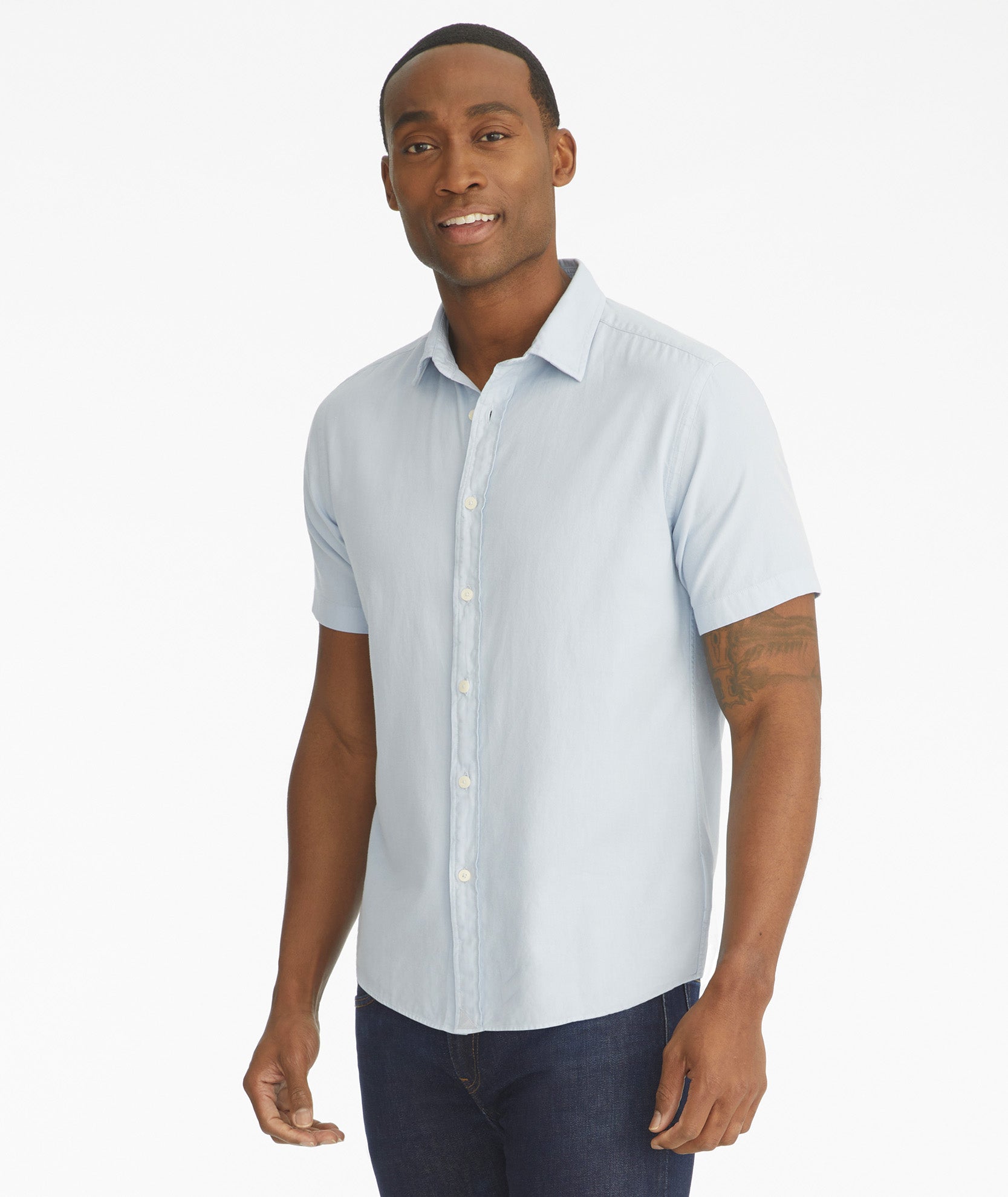 Model is wearing UNTUCKit Briscoe light blue short sleeve button down.