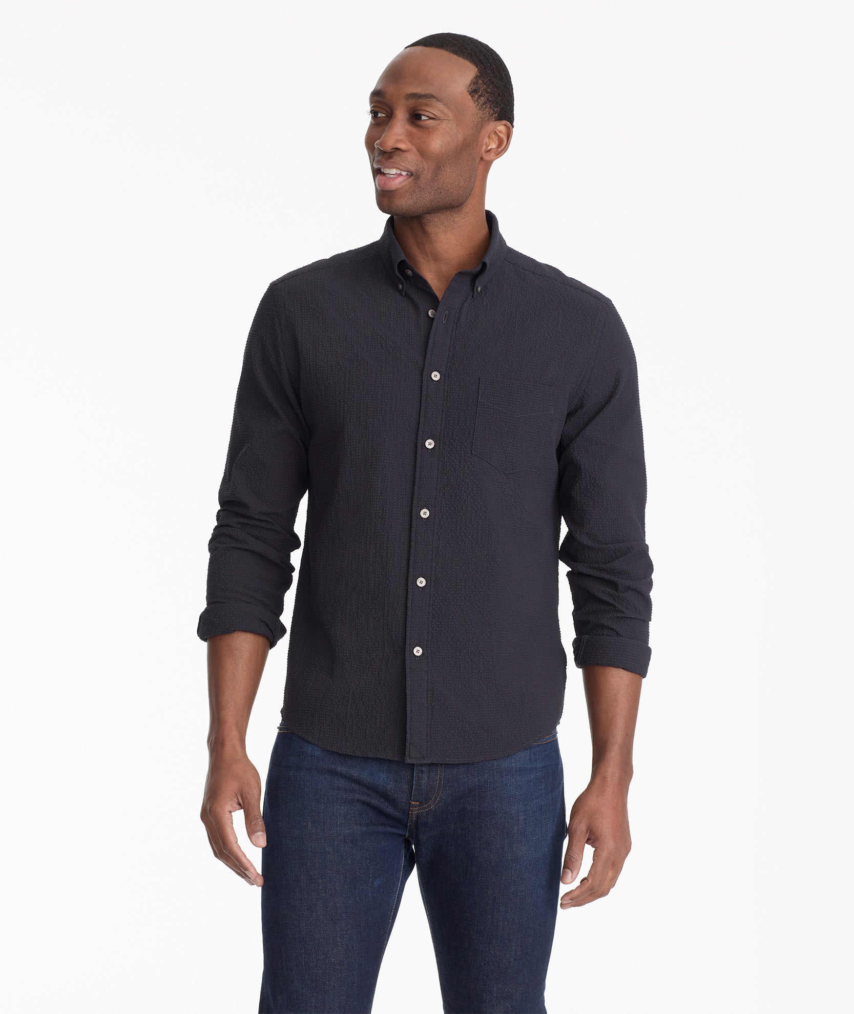 Model is wearing UNTUCKit Cadwell Seersucker shirt in black.