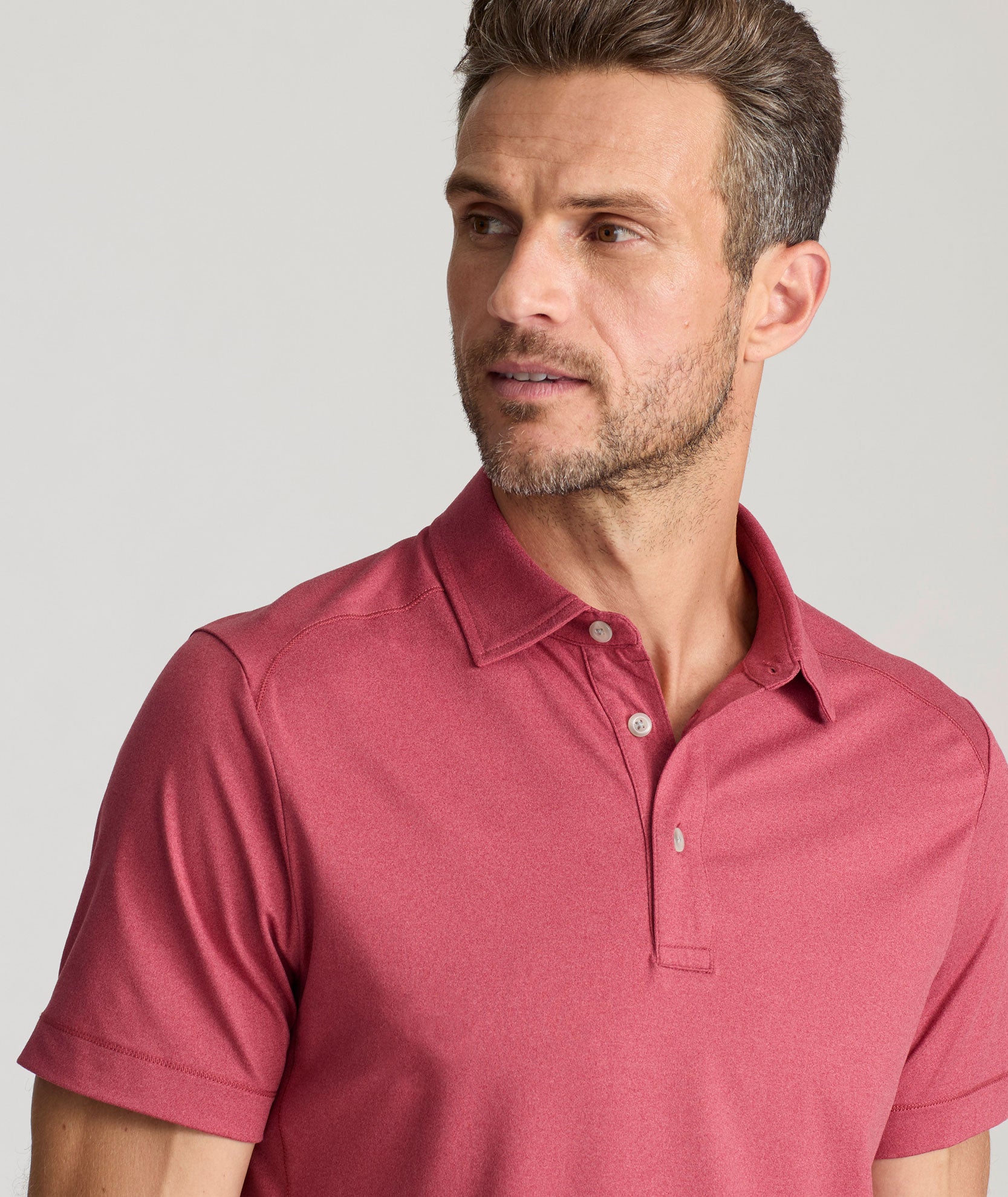 Model wearing a  Performance Polo in faded red.