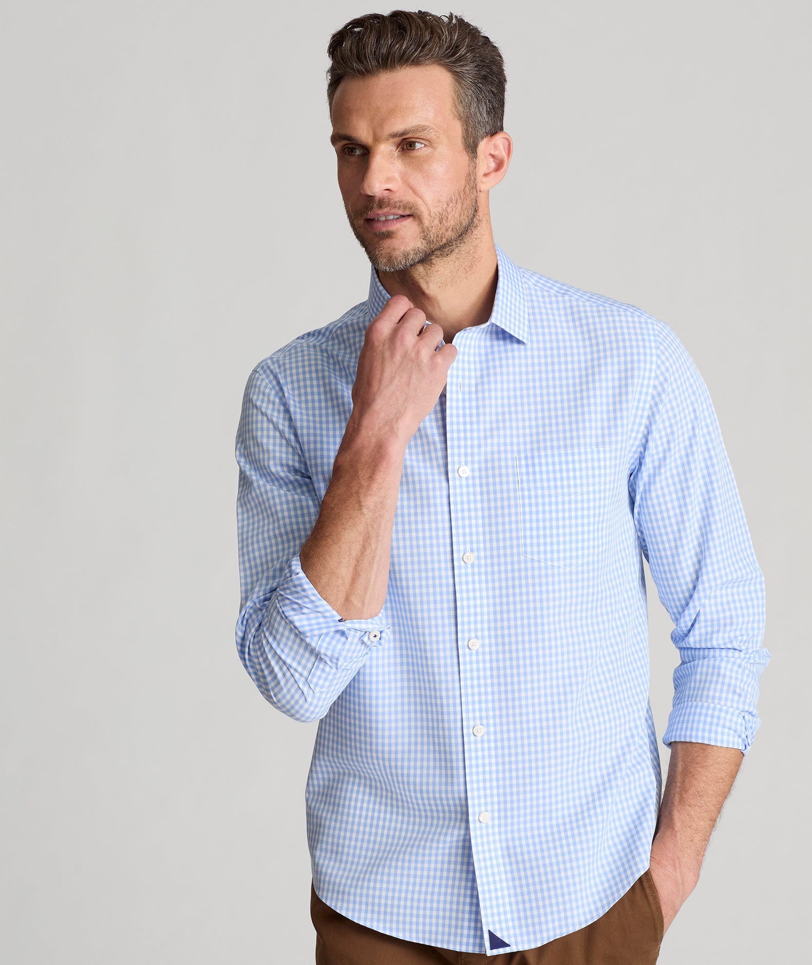 Model is wearing UNTUCKit Lawrence wrinkle free in light blue gingham. 