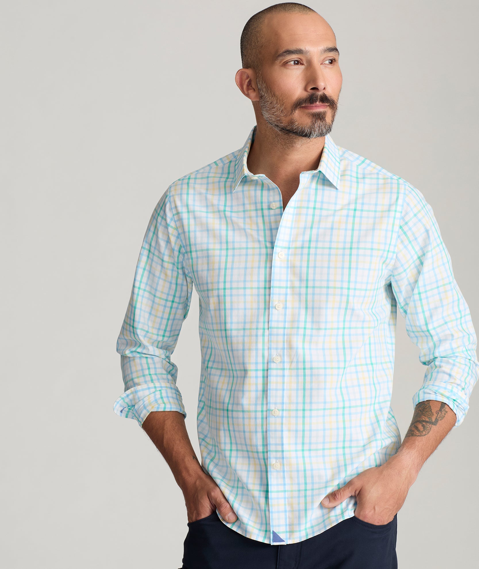 Model is wearing UNTUCKit Moore shirt in green, blue and yellow check. 