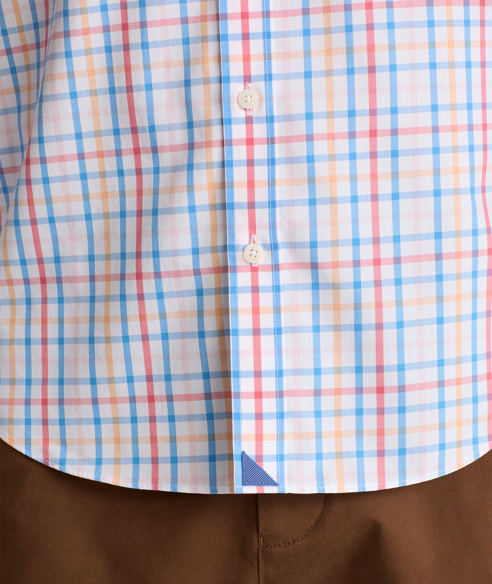 Model is wearing UNTUCKit Moore shirt in blue, orange and pink check.