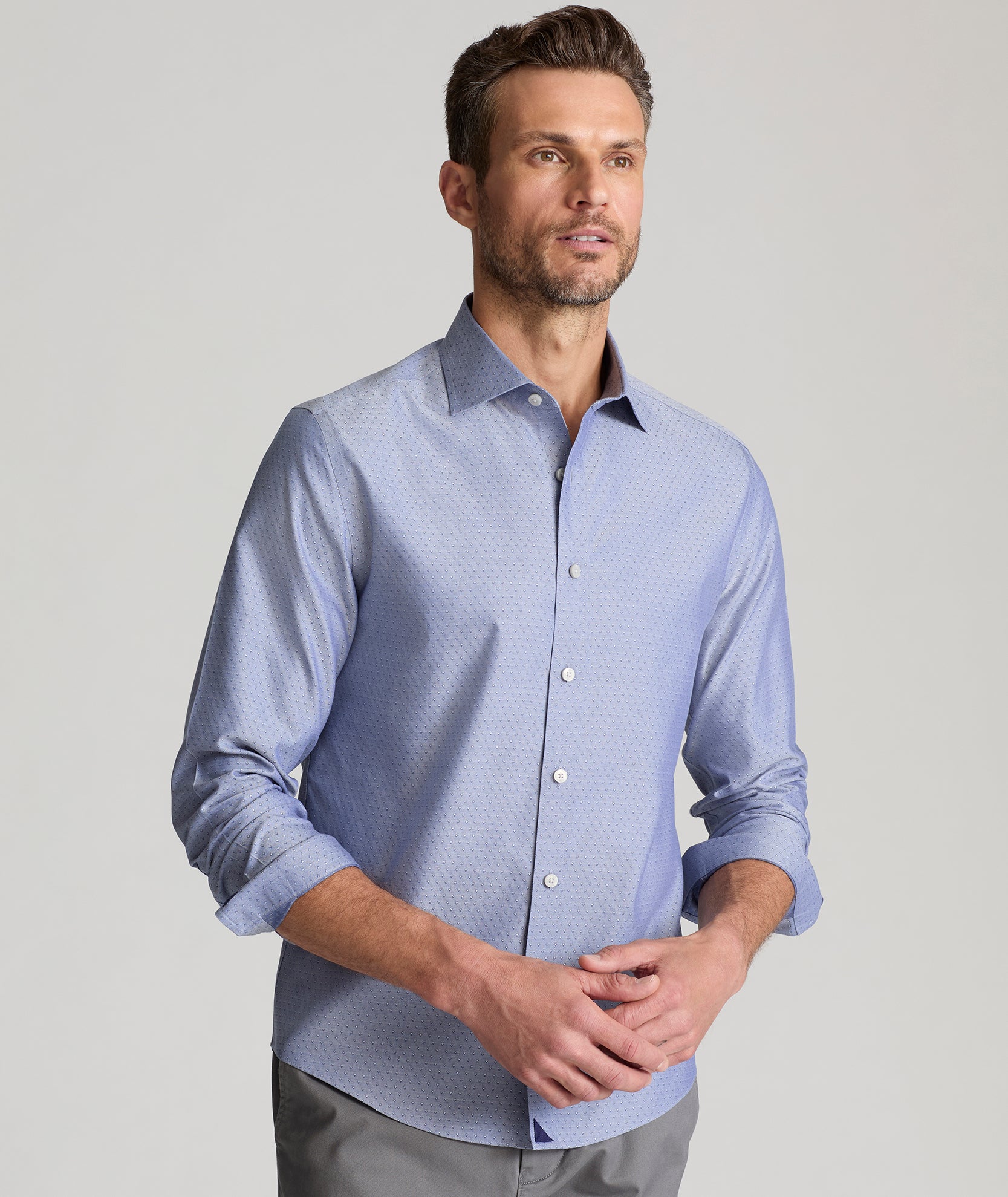 Model is wearing UNTUCKit Oliver wrinkle free shirt in gray blue print. 