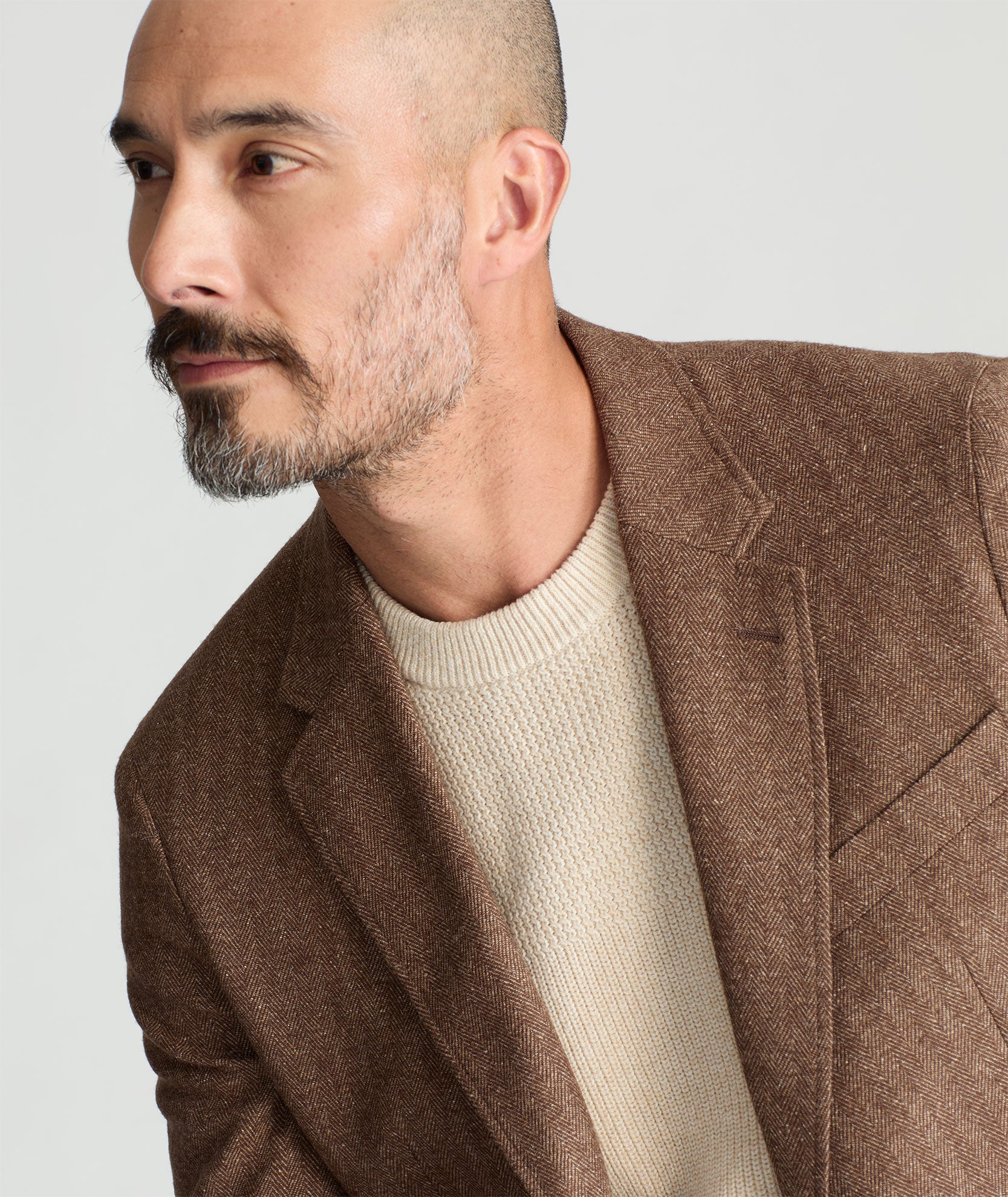 Model is wearing UNTUCKit Italian Wool Rawlins Sport Coat in Tan Herringbone. 