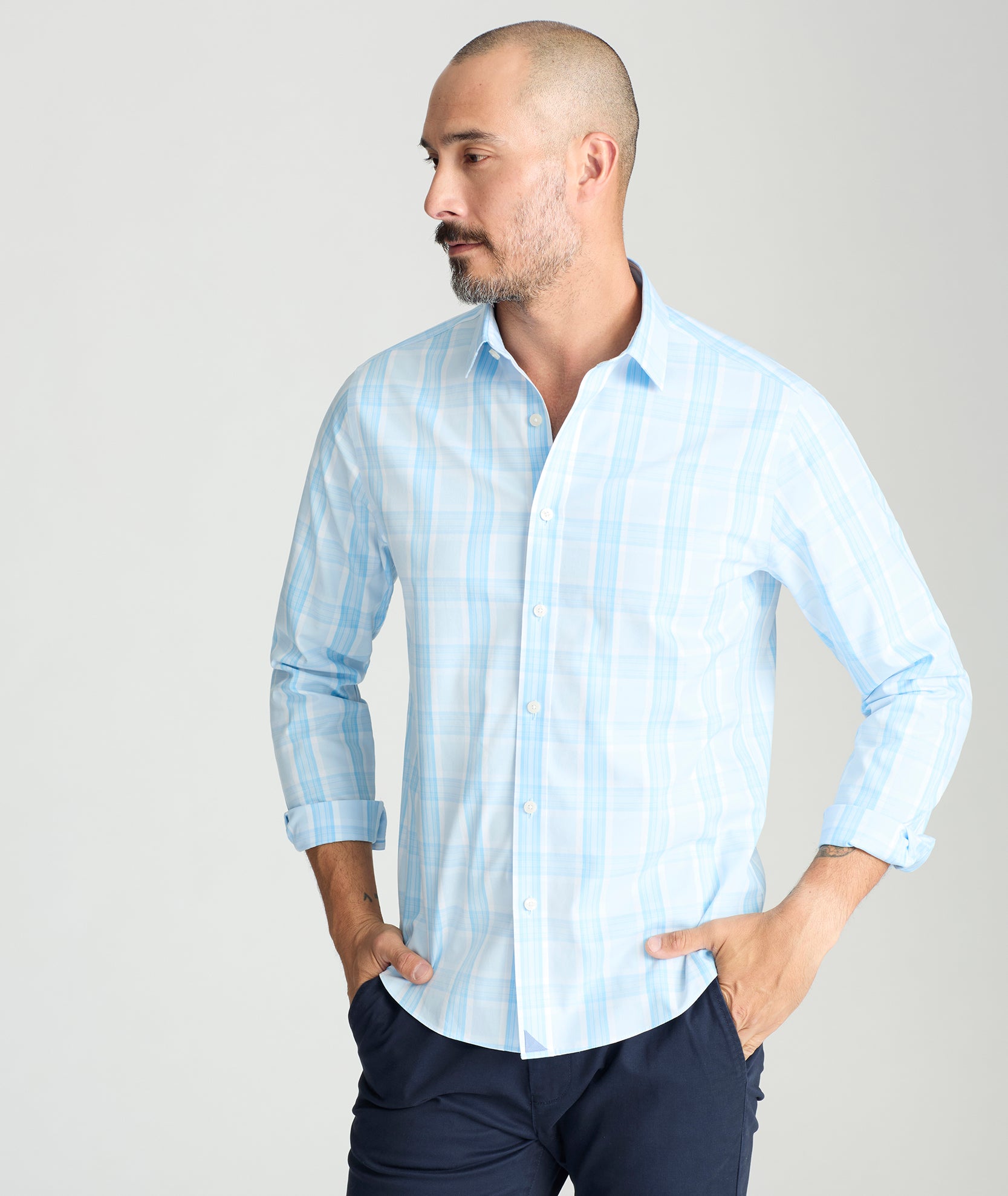 Model is wearing UNTUCKit yates wrinkle-free shirt in light blue large plaid. 