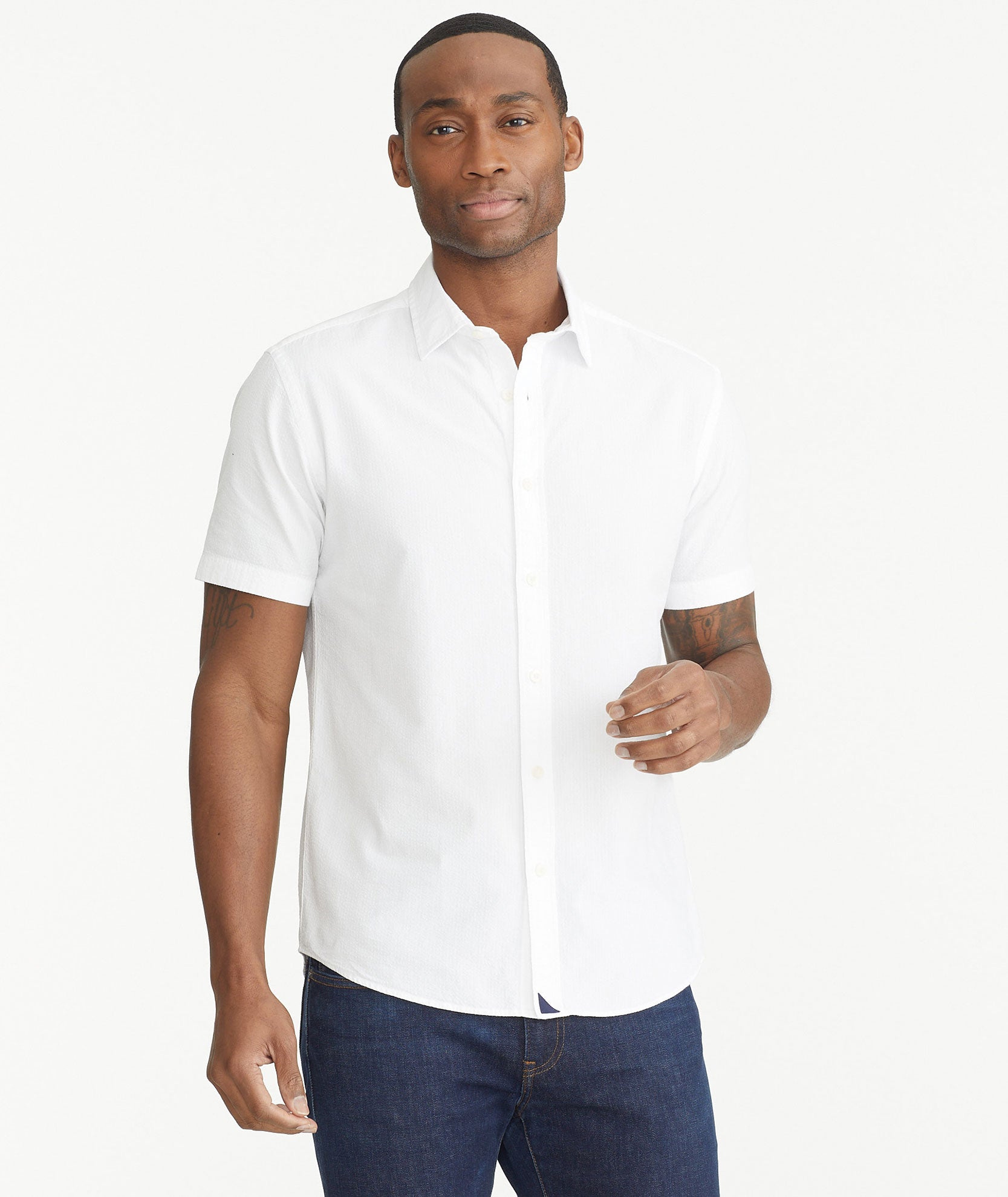 Model is wearing UNTUCKit White Cotton Seersucker Short-Sleeve Pavao Shirt.