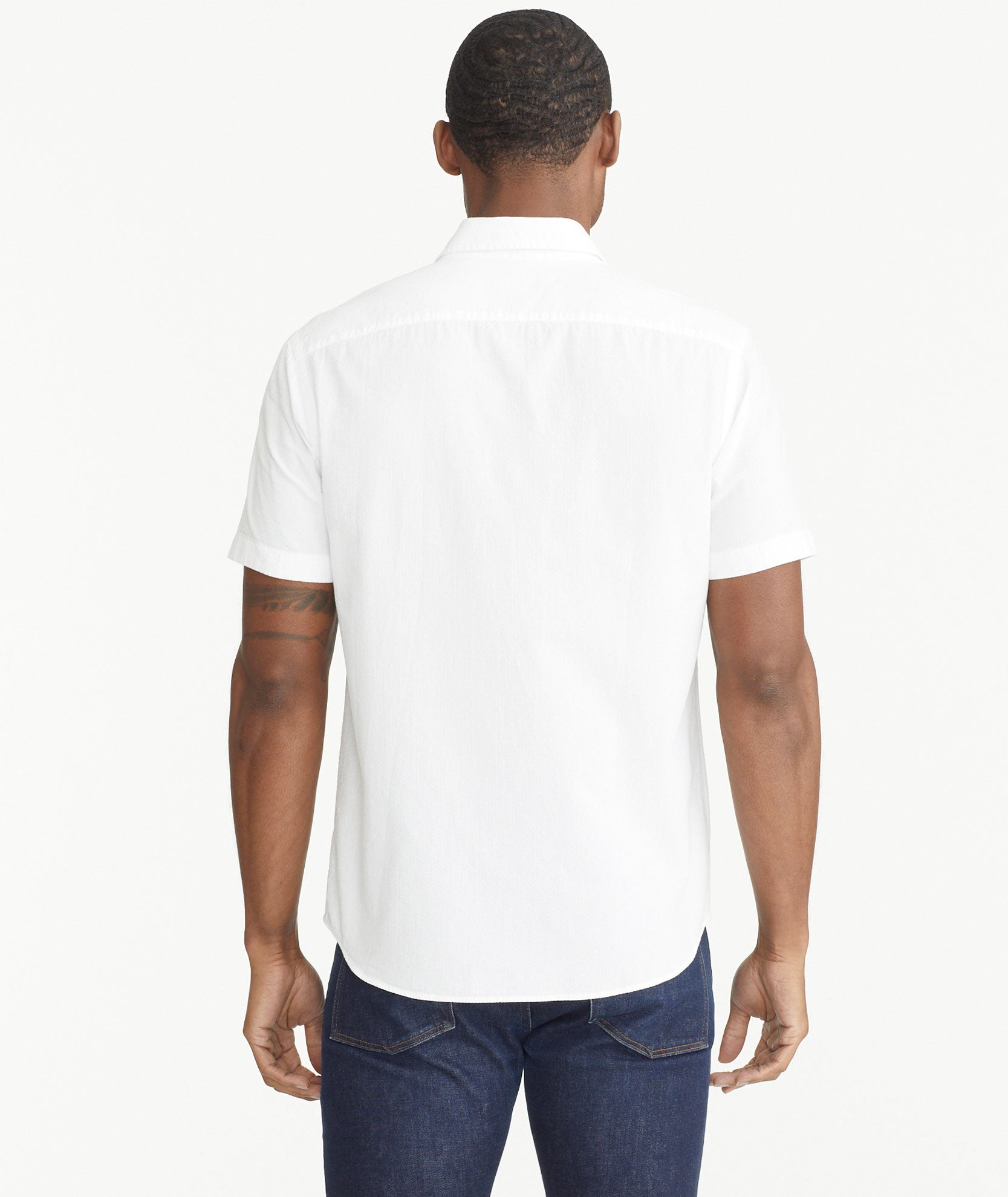 Model is wearing UNTUCKit White Cotton Seersucker Short-Sleeve Pavao Shirt.