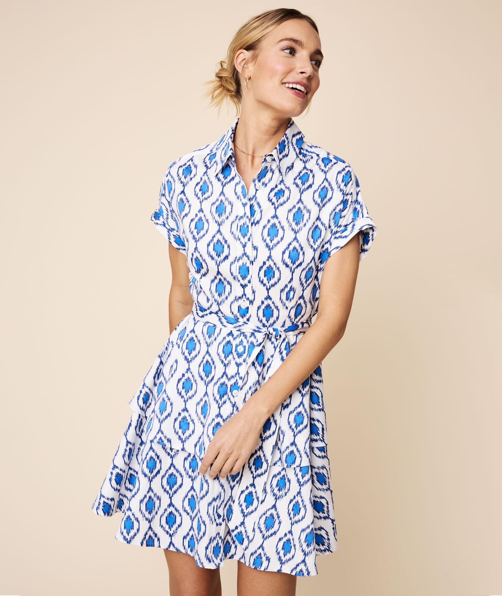 Model is wearing UNTUCKit White and Blue Double Flounce Hem Stretch Cotton Renata Shirtdress.